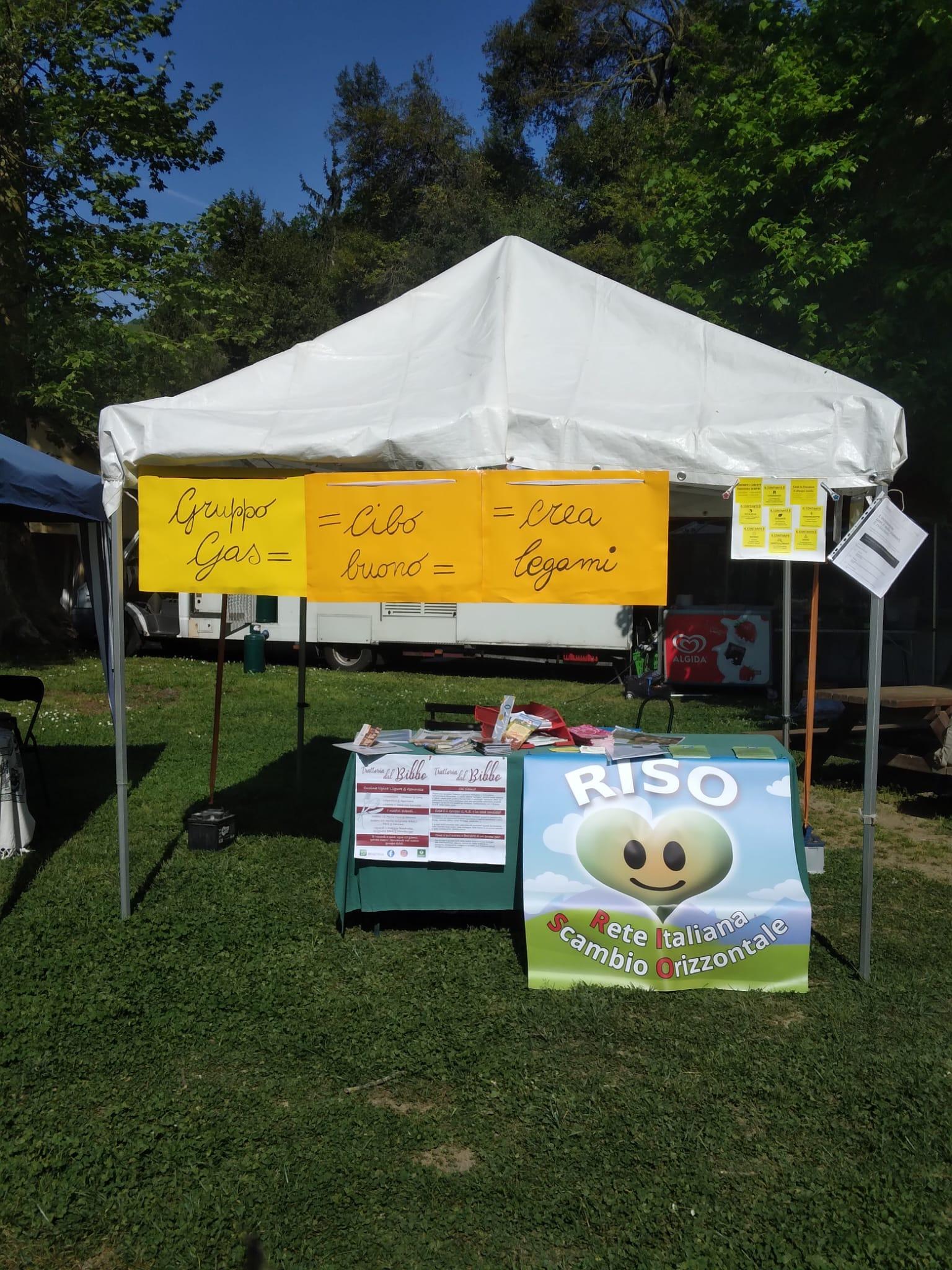 Il nostro gazebo bianco con i cartelli gialli "Gruppo GAS = Cibo Buono = Bei Legami" e il banner del Riso del Dono